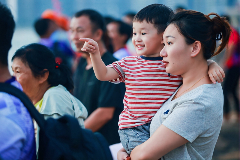 大小观众观看龙舟赛。美兰区委宣传部供图